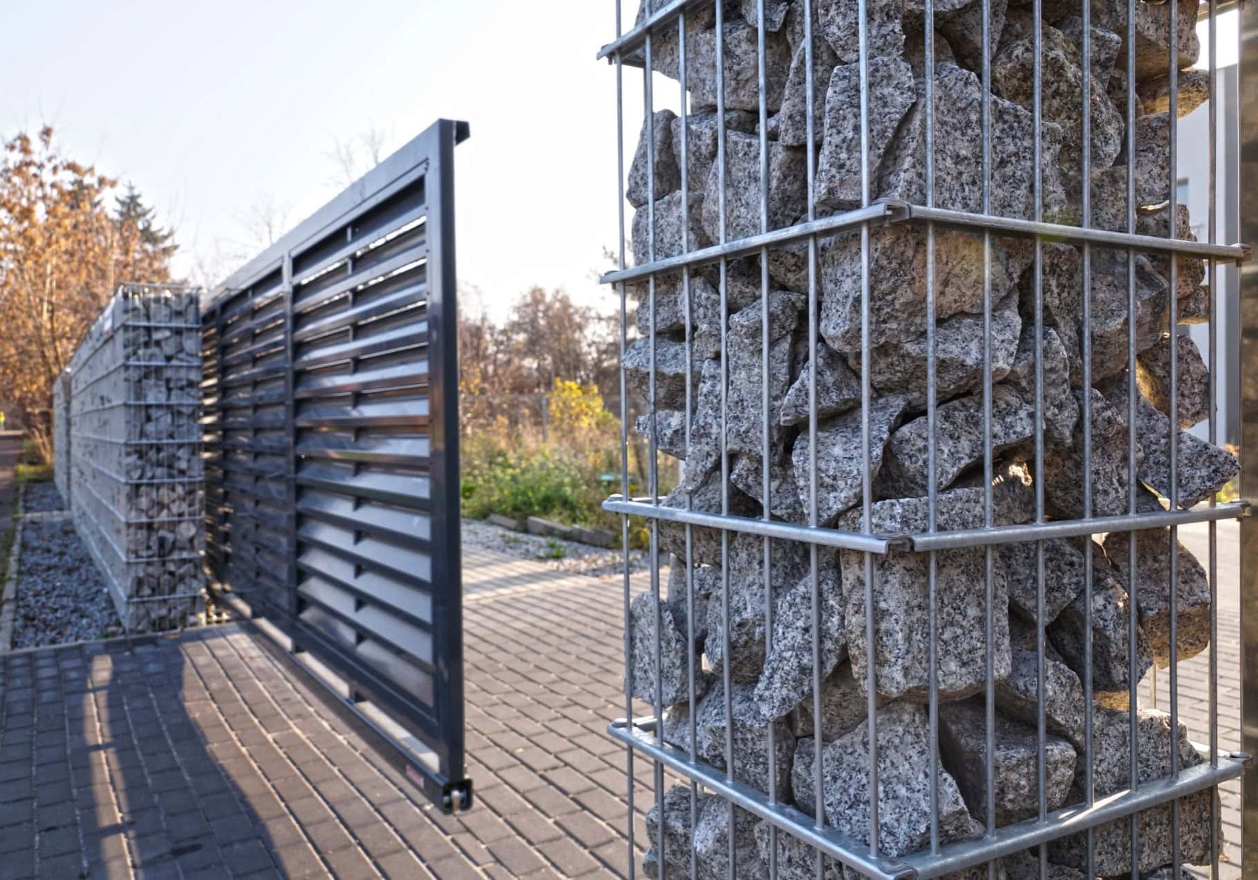 Automated security gate with stone and metal fencing for enhanced property access control.